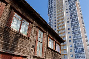Old residential building on the background of a new tall house