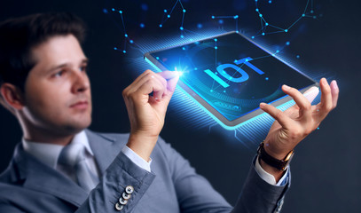 Internet of things - IOT concept. Businessman offer IOT products and solutions. Young businessman  select the abstract chip with text IoT on the virtual display.