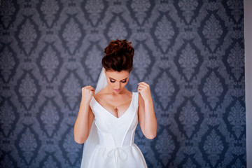 Fototapeta na wymiar morning of the bride, girl trying on a wedding dress