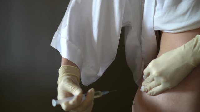 Self-injection of antibiotics. Female preparing needle for injecting her buttocks. Woman injecting buttocks.