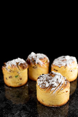 cruffins, The modern baking trend of the year is puffmuffin, a mix of croissants and cupcakes. On a black background sprinkled with powdered sugar