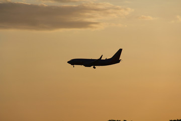 Fototapeta na wymiar silhouette of airplane in sunset with clouds