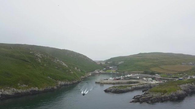 Aerial into Cape Clear island harbour under mist
