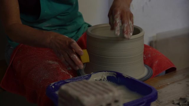 Timelapse of a potter sculpting a bowl with clay. Handcraft shaping vase out of ceramic. Creative artist working on a pottery wheel with hands.