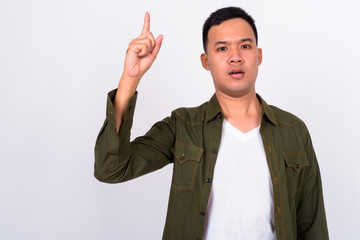 Portrait of young Asian man pointing up