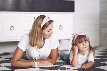 Beautiful woman with child. Woman in a white t-shirt. Little daughter with phone.