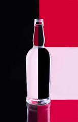 Empty bottle on red-black background