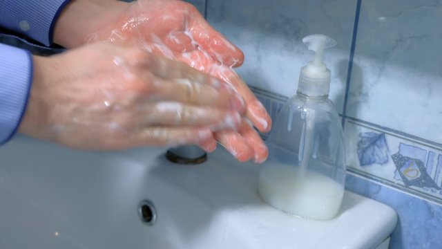 Man is washing hands with antibacterial soap in sink, hands closeup. Fighting spread of coronavirus infection covid-19. Hygienic procedures at home on quarantine and isolation during pandemic. OCD.