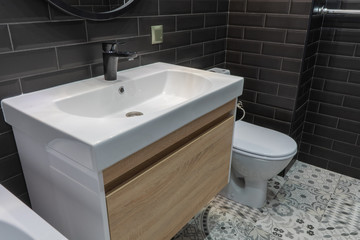 modern bathroom suite with wall mounted wc and sink unit and large mirror