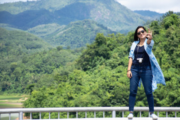 Fototapeta na wymiar Travelers thai women travel visit view of Pattani Dam and walking on barrier concrete on road bridge crossing Bang Lang Reservoir Dam at Bannang Sata District of Yala Province, Thailand