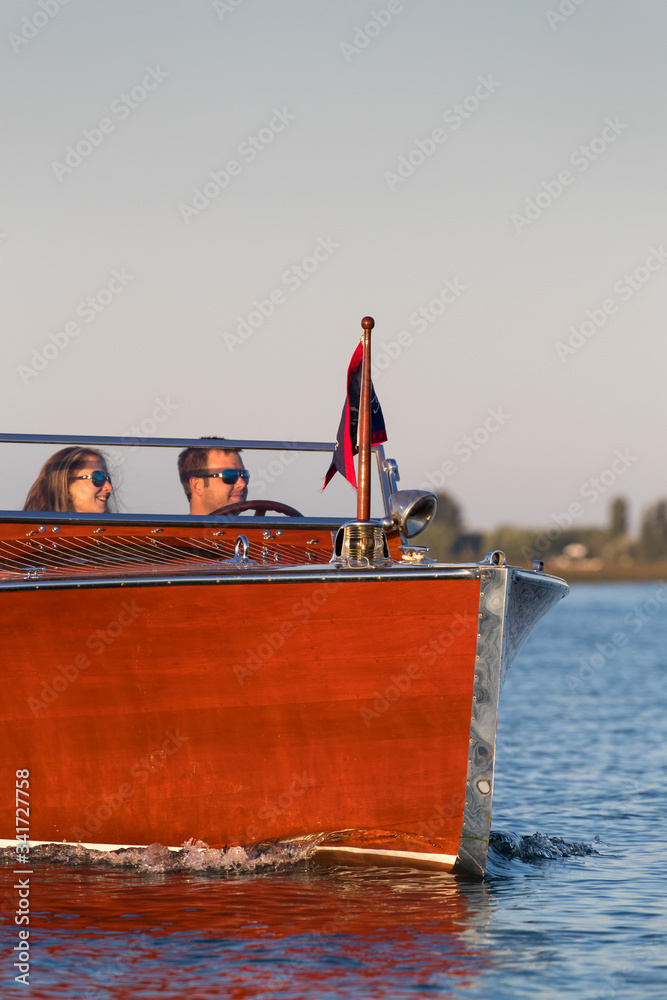 Wall mural young couple in a wood boat.