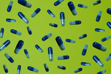 Pattern, several pills, tablets on a green background
