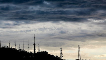 Vista de nuvens de tempestade com a silhueta de torres de comunicação do Morro da Cruz da cidade de Florianópolis, SC, Brasil © Fotos GE