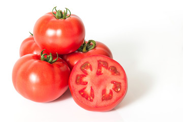 Red fresh tomatoes with sliced one on a white background