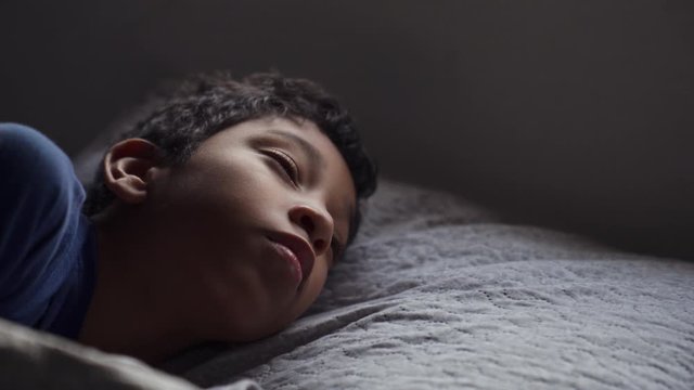 Hispanic Child Sleeping in Bed And Waking Up Early Morning