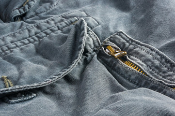 clothing items stonewashed cotton fabric texture with seams, clasps, buttons and rivets, macro