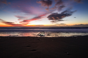 Playa de arena oscura y hielo. Amanecer en Islandia