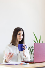 Happy casual woman teleworking from home due to Covid-19 situation. Drinking tea.