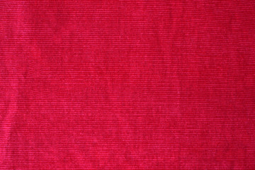 Red velvet fabric texture background. Fragment of a dark red cloth material
