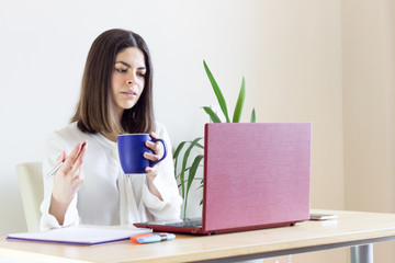 Happy casual woman teleworking from home due to Covid-19 situation. Drinking tea.