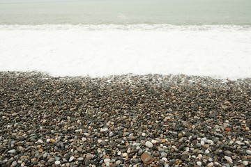 Waves on the beach shore. Shore of rocky pebbles. Mainly cloudy. Day, spring, Georgia.