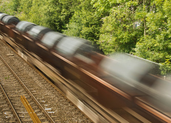 Cardiff, Wales - August 2017: The wagons of a freight train carrying steel coils with slow shutter...