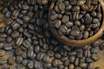 Roasted Coffee beans on grunge wooden can be used as a background
