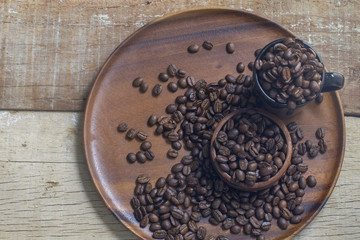 Roasted Coffee beans on grunge wooden can be used as a background