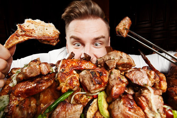 Crazy hungry man eating mix grill meat. Emotional content for restaurant promo. Cheat day. Meat lover. Lamb chops, chicken tikka, kebab, lamb, beef steak. Enjoy your food - 341736759