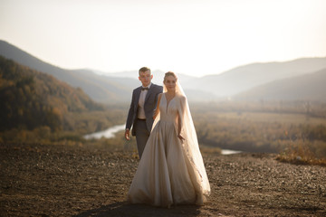 Wedding photo session of the bride and groom in the mountains. Photoshoot at sunset.