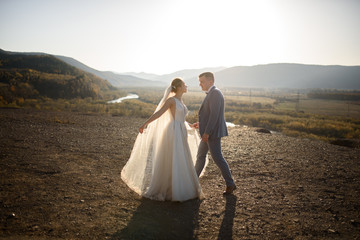 Wedding photo session of the bride and groom in the mountains. Photoshoot at sunset.