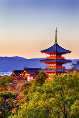 Fototapeta premium Japanese Heritage. Renowned Kiyomizu-dera Temple Pagoda Against Kyoto Skyline and Traditional Red Maple Trees in Background in Japan.