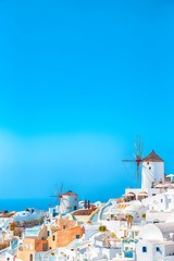 Greek Traditional White Houses and Windmills of Oia or Ia at Santorini Island in Greece at Noon.