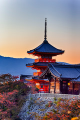 Fototapeta premium Japanese Heritage. Vivid Sunset Over Kiyomizu-dera Temple Pagoda With Traditional Red Maple Trees in Background in Kyoto, Japan