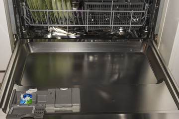 Close up view of open dishwasher. Technology background, 