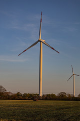 Traktor bei der Direktsaat vor Windrad