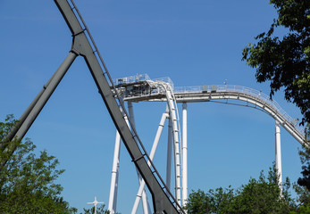 rollercoaster track curving down . Blue sky background