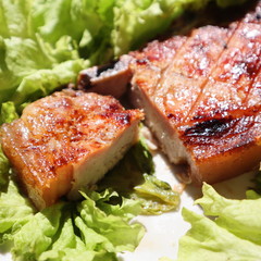Juicy pork steak grilled on a plate on a fresh green salad