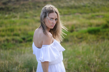 Fototapeta na wymiar portrait of a beautiful girl of a blouse of Slavic origin. Beautiful blonde girl in a field on a hot summer day.