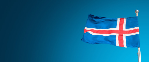 Banner with blue Icelandic national civil flag with red and white cross at blue sky background with copy space for text, closeup, details