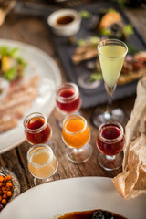 Shots cherry lemon apple cranberry on wooden table at feast with plates restaurant