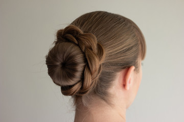 Young Caucasian woman with blonde hair wearing a self-made french bun back side view no face...