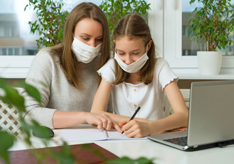 Schoolgirl with her mother at distance learning, doing homework. Home schooling concept.