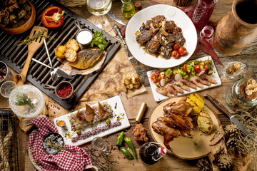 Plate with grilled beef ribs fish bruschetta on wooden table at hunter restaurant cafe daylight