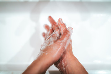 Fototapeta premium soaped hands while washing at home