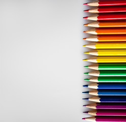 Colored pencils are placed according to the colors of the LGBT flag on a white or gray background:...