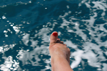 a raised toe on the right foot against the background of water