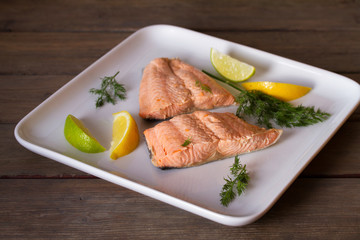Poached salmon fillets. Boiled salmon on white plate. Healthy diet fish dish