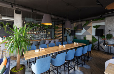 Cute restaurant interior with sofas and wooden tables