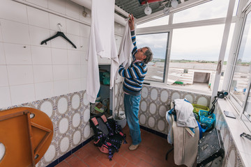 Senior man hanging clothes.